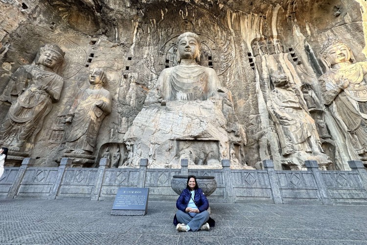 Amrit Singh in front of large Buddha statue in Dazu, China