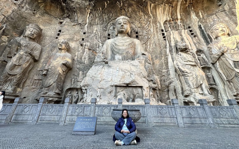 Amrit Singh in front of large Buddha statue in Dazu, China