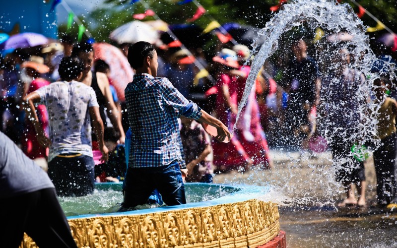 Boy splashing water in fountain during water-Sprinkling Festival in Yunnan, China
