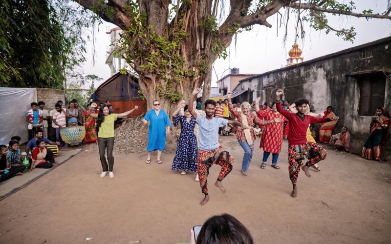 Travellers enjoying The Chhau Festival dancing with a local community
